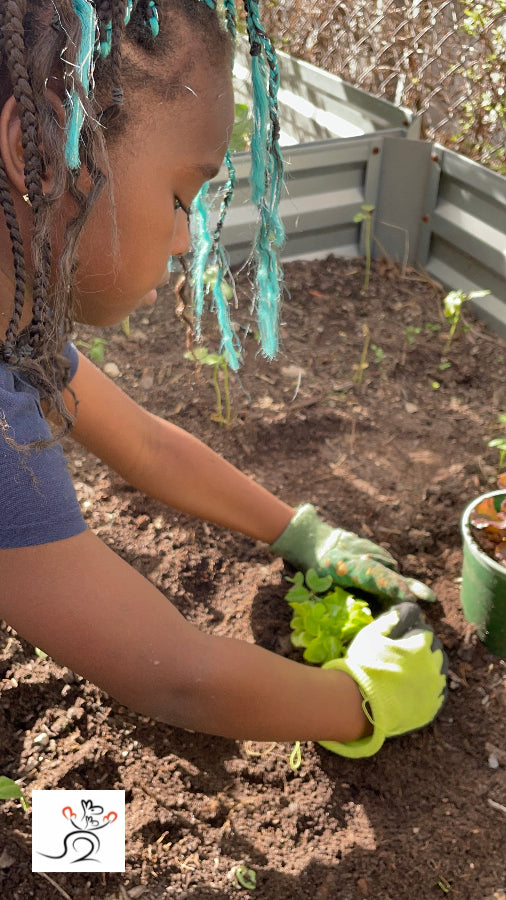 Girl planting vegetables in community garden